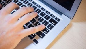 hand typing on laptop keyboard