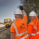 two workers acknowledging a train's signal
